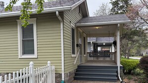 A house with a porch, steps, and a white picket fence.