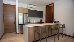 Eine moderne Küche mit einer zentralen Kochinsel, Edelstahlgeräten und einem eingebauten Backofen.