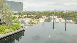 Piscina infinita no terraço com vista desimpedida da cidade.