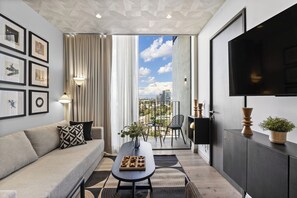 Ein modernes Wohnzimmer mit Sofa, Couchtisch und Kunstwerken an der Wand.