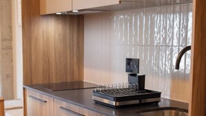 A modern kitchen with wooden cabinets, a stainless steel countertop, a built-in microwave, and a coffee machine. - Mr W | 1BR Margot Loft Modern City Tower (Guadalajara)