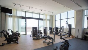 Ein Fitnessstudio mit Cardiogeräten, Kraftstationen und großen Fenstern.