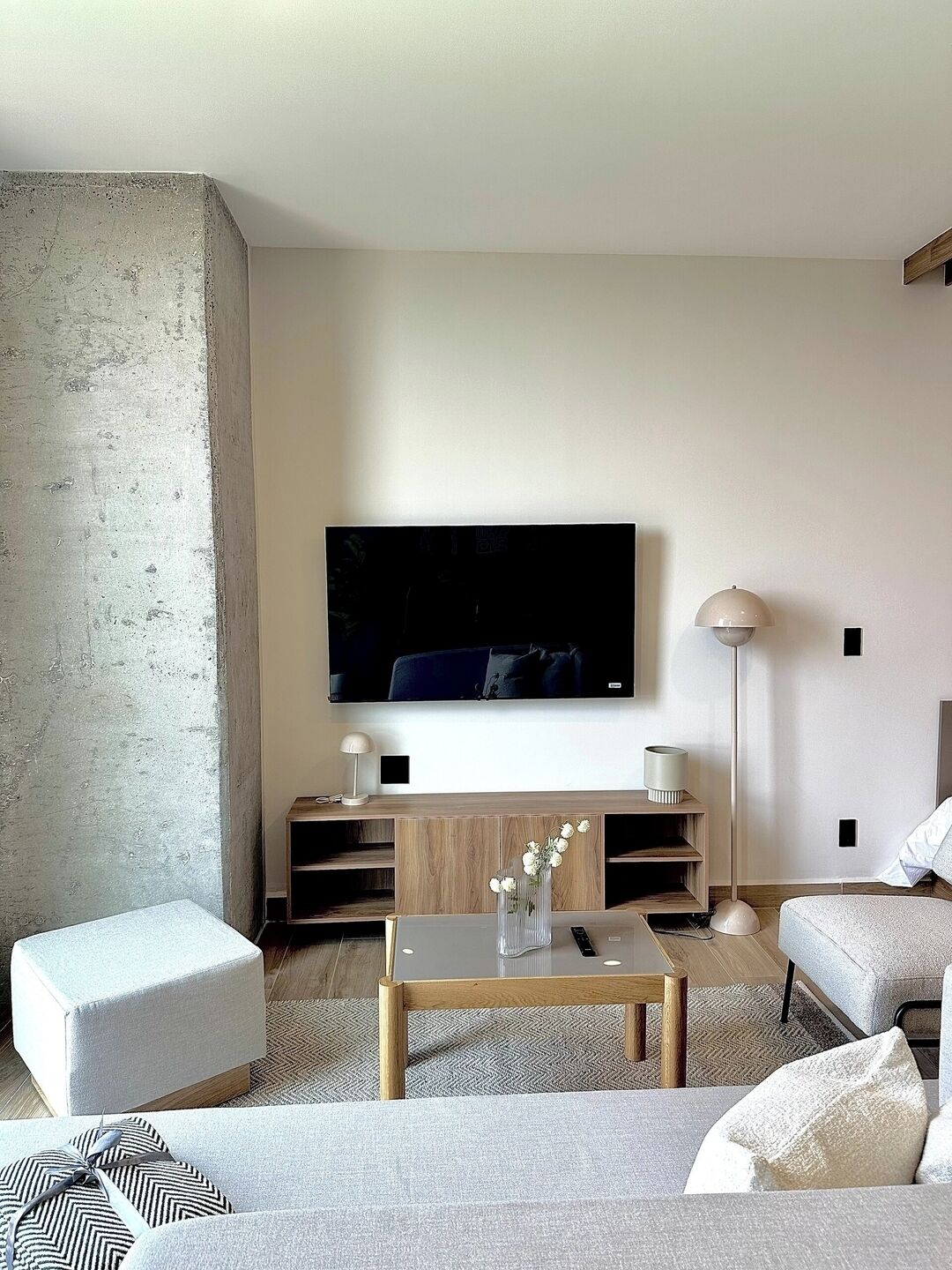 Un salon moderne doté d’un téléviseur à écran plat, d’une table basse et de sièges.