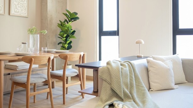 Un espace de vie moderne comprenant un coin repas, un canapé et une grande fenêtre.