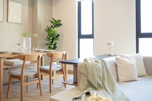 Un espace de vie moderne comprenant un coin repas, un canapé et une grande fenêtre.