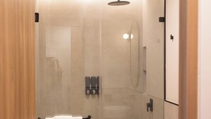 Une salle de bain moderne dotée d ’une douche à parois de verre, de toilettes et d’un lavabo.