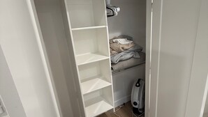 A small bedroom with a bed, a heater, and a wardrobe with open doors. - 2-bedroom apartment in Utah County (American Fork)