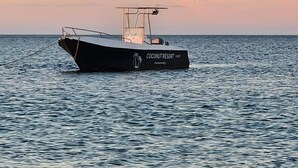 A boat named 'Coconutsort' on the water. - Private Villa with Sea View & Whirlpool Tub (201) (Soalara Bas)