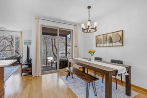 A dining area with a wooden table, benches, and a chandelier. - Riverfront•Prime Location•Park and Walk! (Salida)