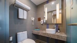 A modern bathroom with a toilet, sink, mirror, towel rack, and a hand dryer. - Muwang Hotel Dalian (Dalian)