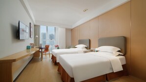 A hotel room with two beds, a desk, a chair, and a large window with a city view. - Muwang Hotel Dalian (Dalian)