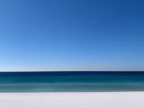 Ein Strand mit blauem Himmel und ruhiger See.