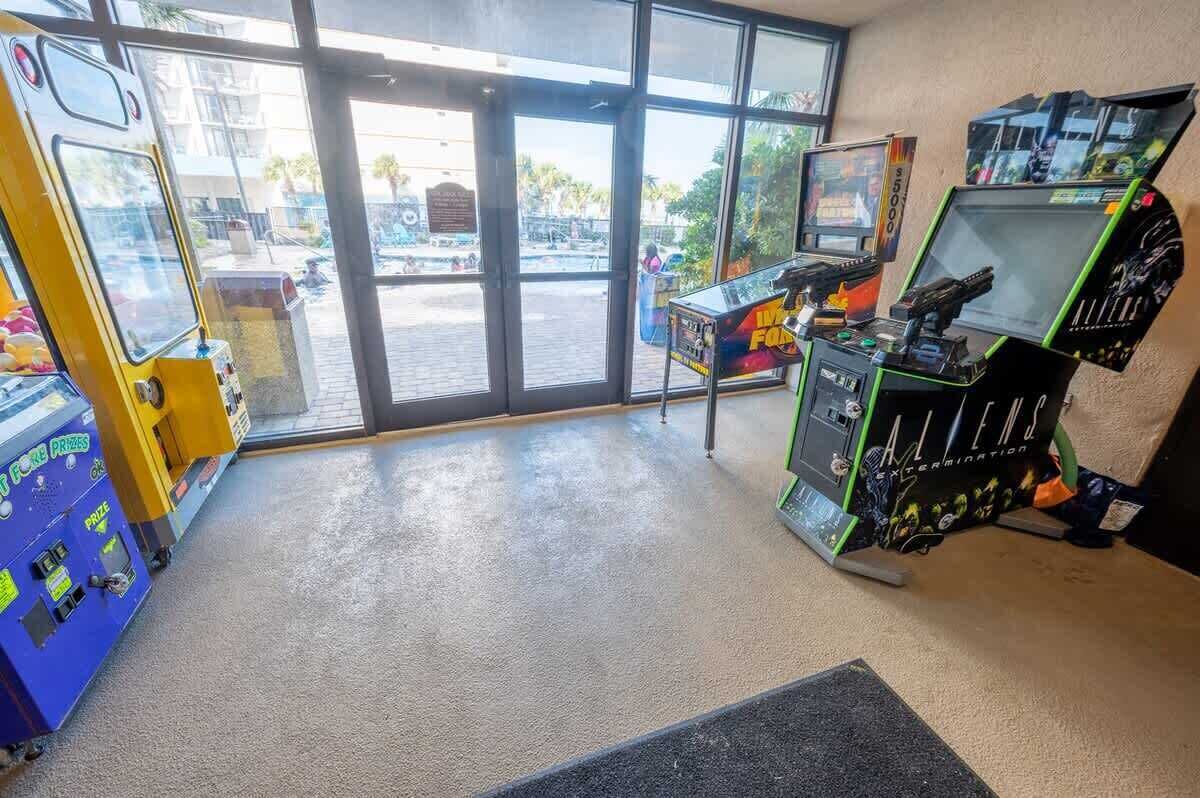 A room with a large window, a vending machine, and a gaming machine.
