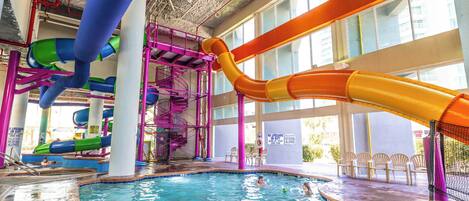 Ein großer Indoor-Wasserpark mit mehreren Wasserrutschen und einem Poolbereich.