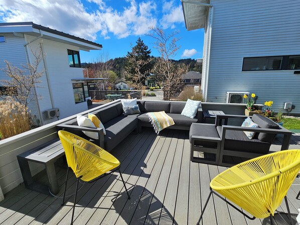 A deck with a sofa, chairs, and a table.
