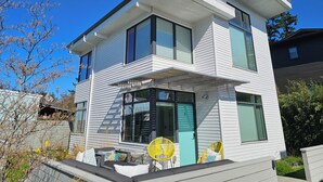 A modern two-story house with a balcony, large windows, and a number '450' on the front.
