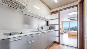 Una cocina moderna con microondas, pileta y extractor.