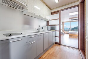 A modern kitchen with a microwave, sink, and ventilation hood.