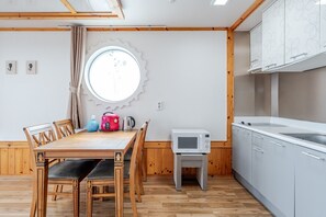 A compact kitchen with a microwave, kettle, and kettle on the counter.