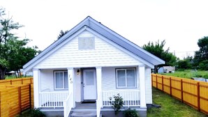 Une petite maison de plain-pied, avec un porche à l’avant, une boîte aux lettres et le numéro « 140 » peint sur le mur.