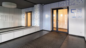 Un interno moderno con una reception, un muro decorato e una porta che conduce in un'altra stanza.