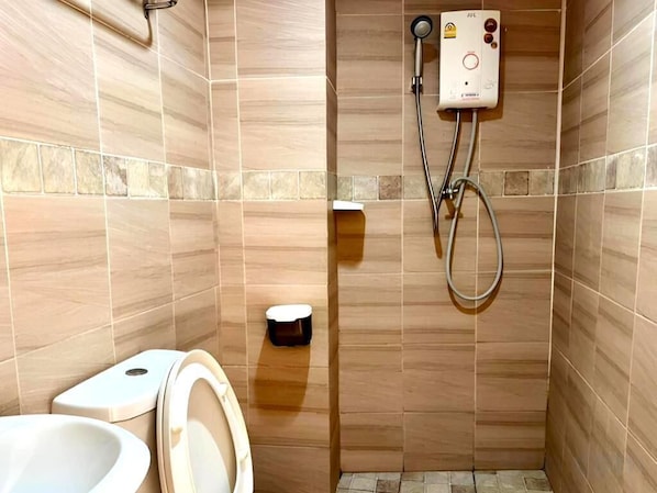 Un baño con inodoro, bidé y cabina de ducha.