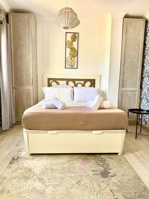 A bedroom with a bed, a hanging light fixture, a framed leaf artwork, and a small table. - Sea Views|Canteras beach|1 min walk|Chic (Las Palmas de Gran Canaria)
