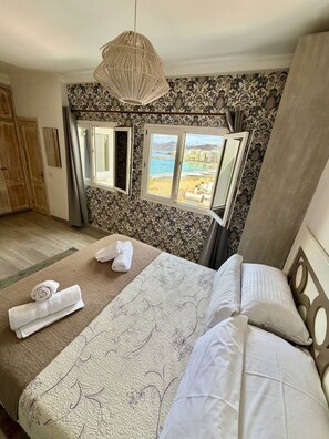 A bedroom with a bed, a window with a view, a hanging light fixture, and a door. - Sea Views|Canteras beach|1 min walk|Chic (Las Palmas de Gran Canaria)