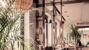 A modern interior with a dining area, seating, and a staircase. - Cook's Club City Beach Rhodes (Rhodes)