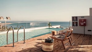 A wooden deck with a pool, lounge chairs, and a view of the ocean. - Cook's Club City Beach Rhodes (Rhodes)