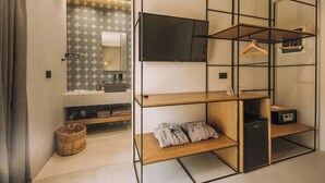 A modern hotel room with a wooden console table, a black refrigerator, a TV mounted on the wall, and a patterned wall. - Cook's Club City Beach Rhodes (Rhodes)