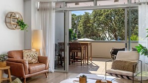 Ein modernes Wohnzimmer mit einer Ledersofa, einem Couchtisch und einem Essbereich mit Tisch und Stühlen.