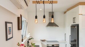 Una cocina moderna con una isla central, iluminación colgante, electrodomésticos integrados y un diseño minimalista.