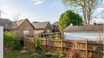 A residential area with houses, a wooden fence, and a tree.