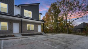 Un bâtiment à deux étages, doté d’une façade en briques, de nombreuses fenêtres et d’un espace de stationnement.