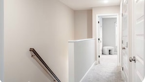 Un couloir avec une porte blanche, un mur blanc et une moquette blanche.