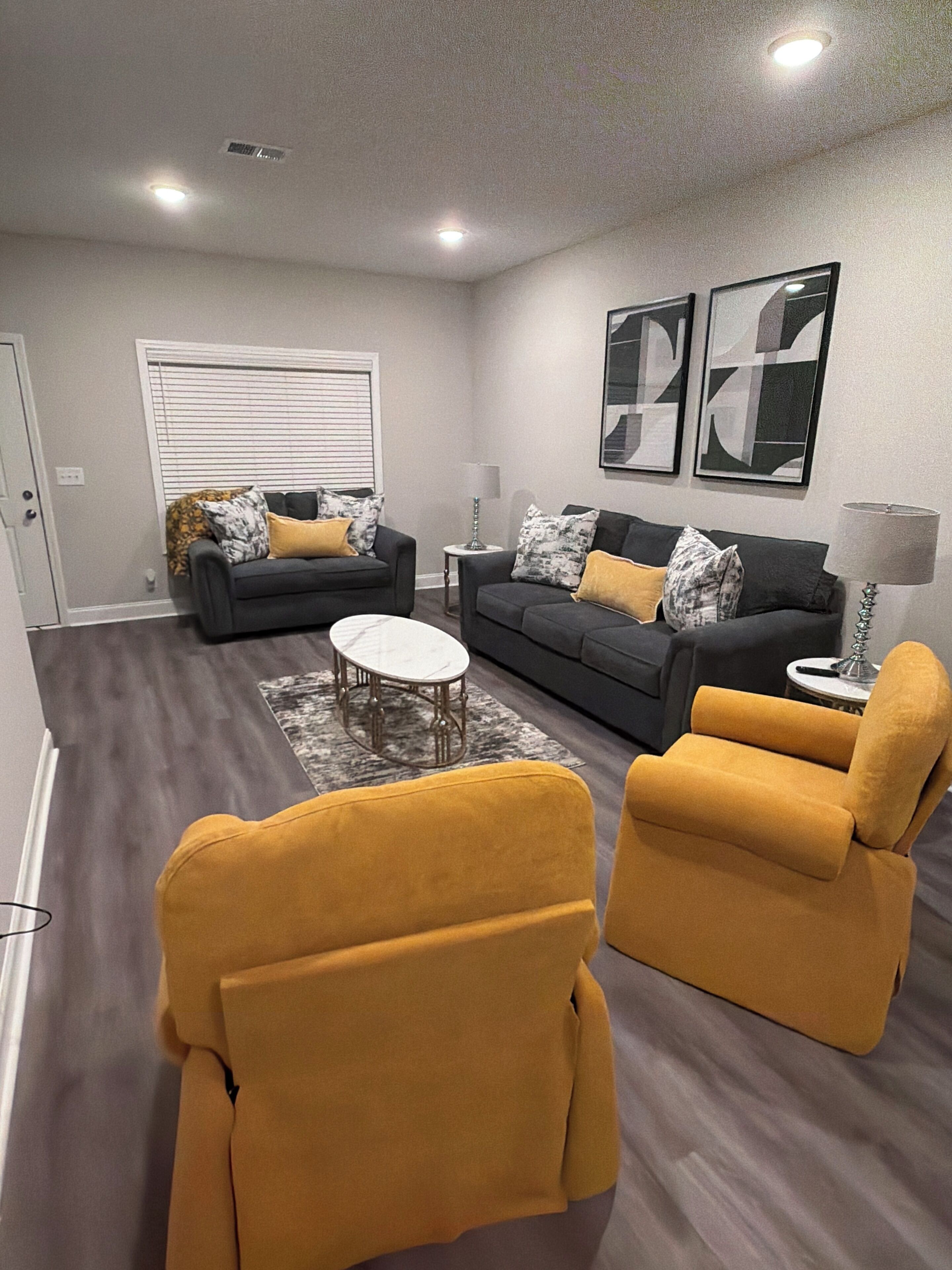 A living room with two sofas, a coffee table, and two armchairs.