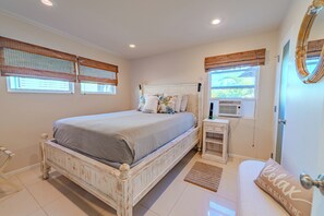 Une chambre à coucher avec un lit, une table de chevet et une fenêtre donnant sur un beau paysage.