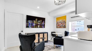 A modern kitchen with a white countertop, black chairs, and a dining area with a round table. - Cozy 1-bedroom apartment with kitchen in peaceful Tavernier/Key largo (Tavernier)