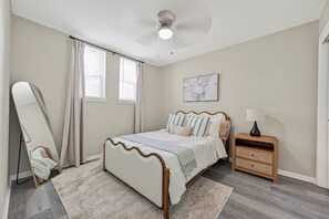 A bedroom with a bed, a nightstand, a mirror, and a ceiling fan. - Beautiful 3 bedroom home in peaceful Spring / Cypress area near downtown Houston (Houston)