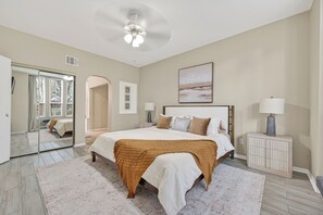 A bedroom with a bed, bedside lamps, a ceiling fan, a painting, and a view through a window. - Beautiful 3 bedroom home in peaceful Spring / Cypress area near downtown Houston (Houston)