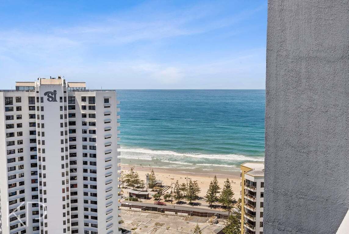 A high-rise building with a view of the ocean and beach.