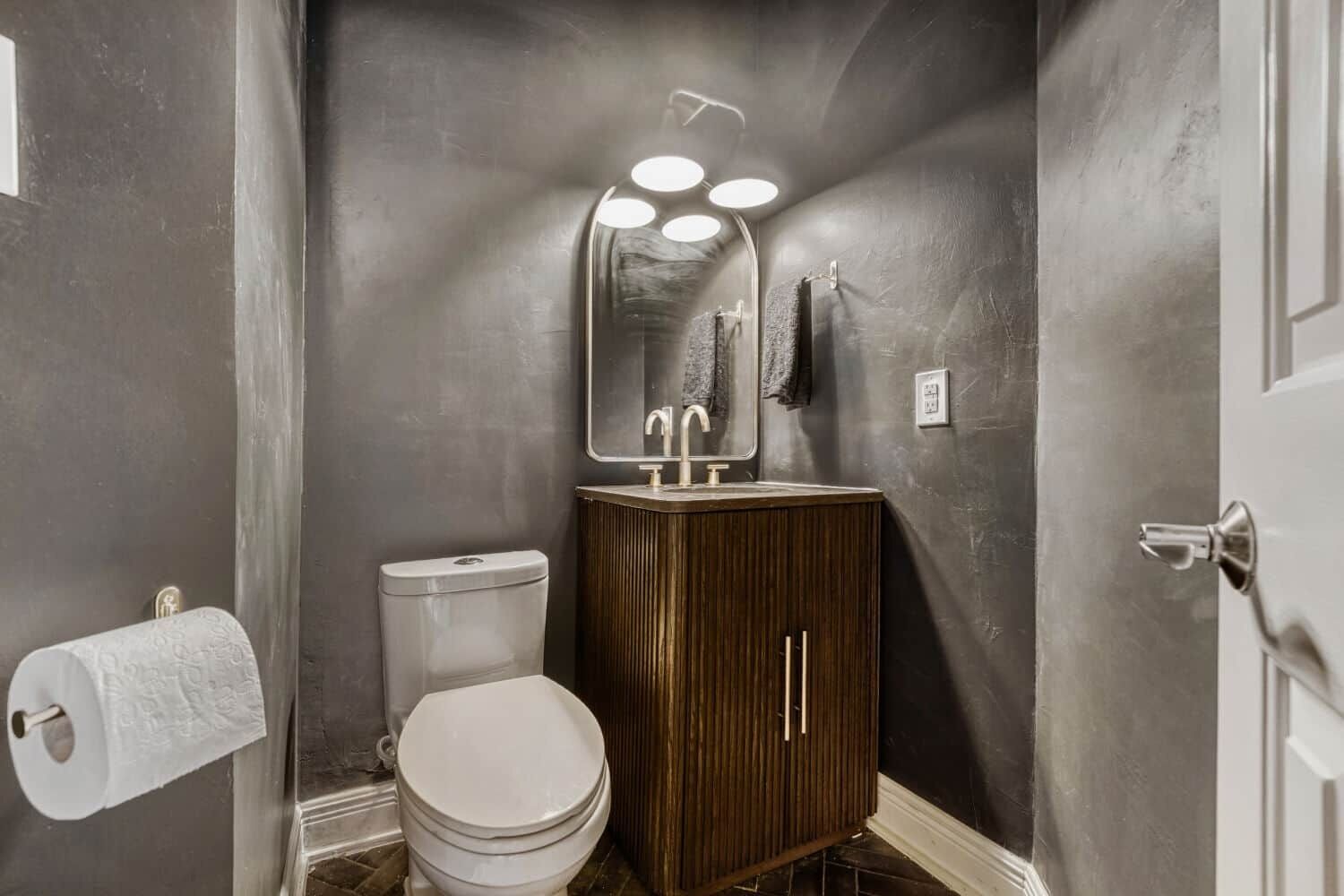 Ein Badezimmer mit Toilette, Waschbecken und Spiegel.