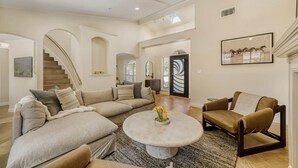 A spacious living room with a sectional sofa, a round coffee table, and a fireplace. - LuxuryLake Austin Retreat: Game Room + Fire Pit, Minutes to Downtown (Austin)