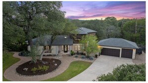 A two-story house with a garage, surrounded by trees and a landscaped yard. - LuxuryLake Austin Retreat: Game Room + Fire Pit, Minutes to Downtown (Austin)