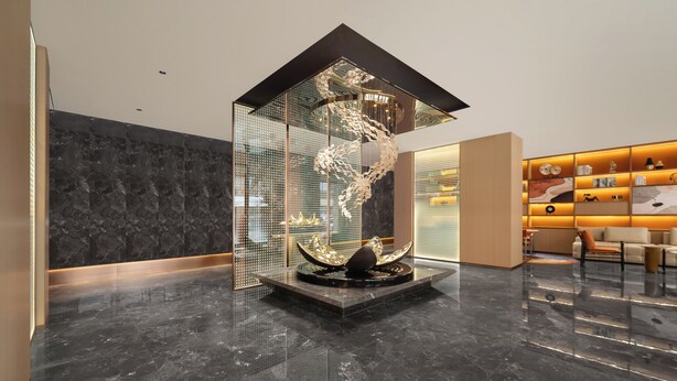 Un hall con una escultura moderna, una recepción y una zona de estar.
