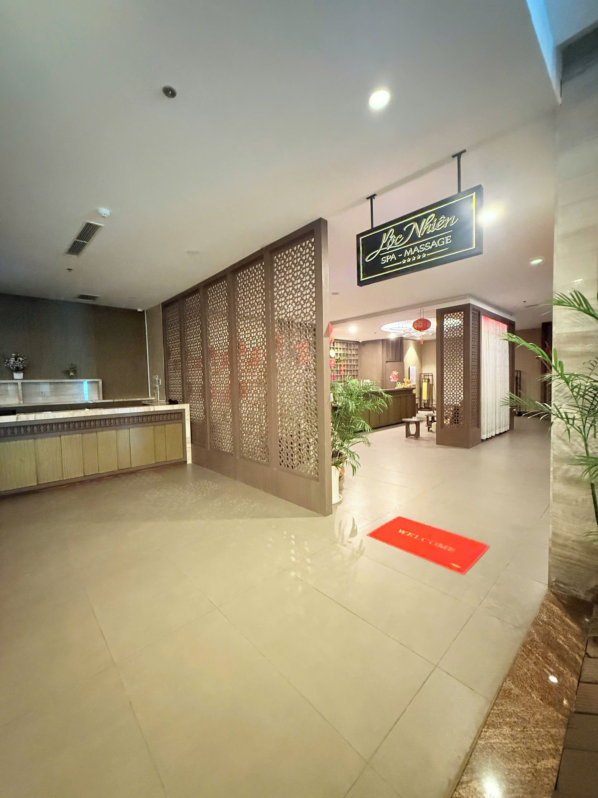 A reception area with a decorative partition, a reception desk, and a sign for a spa and massage service.