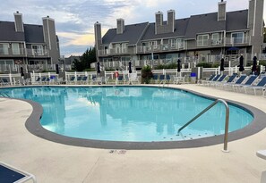 A swimming pool with lounge chairs and a white fence. - Waterfront Harbour Island Downtown Stunning Bay View Walk to Beach & Boardwalk (Ocean City)