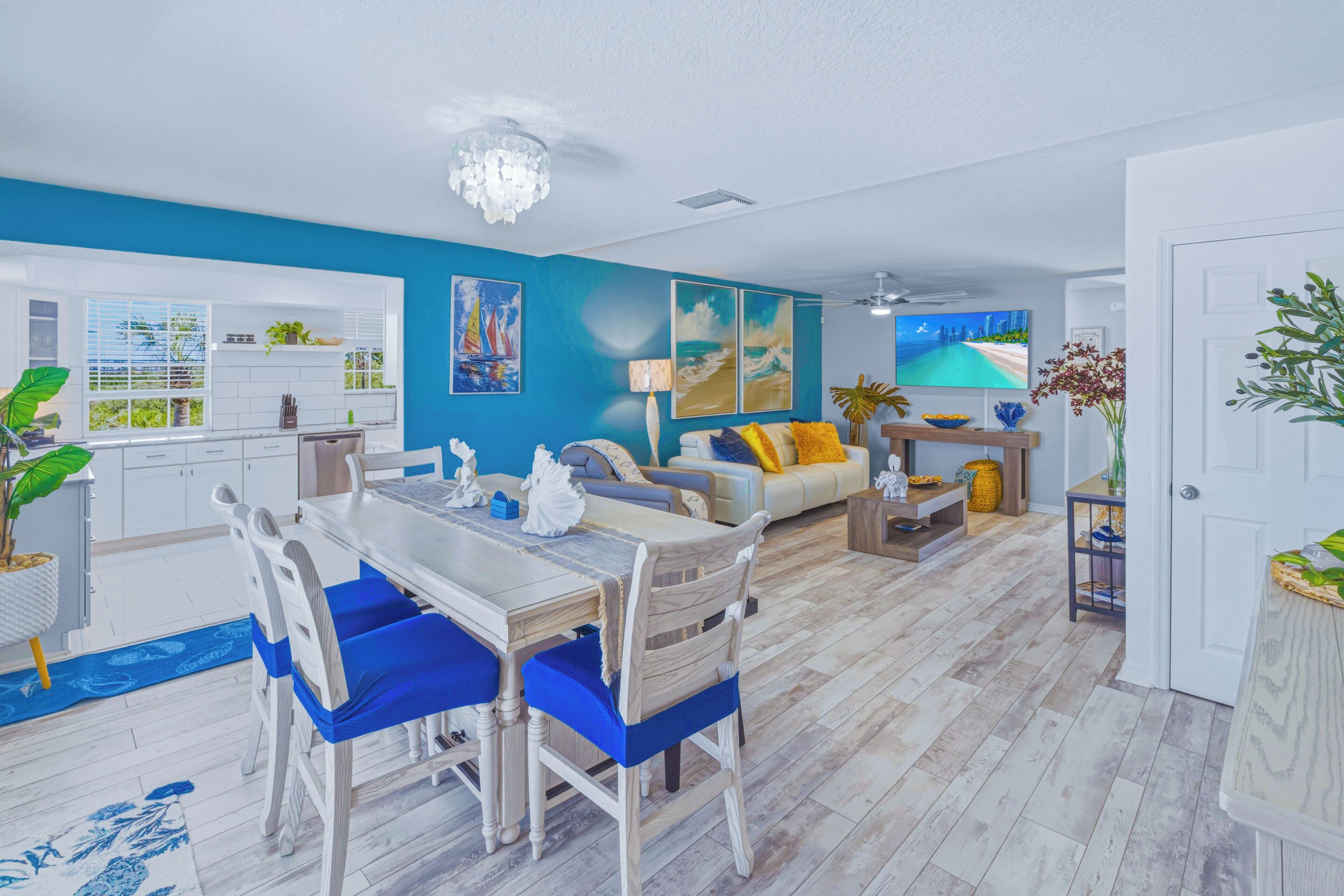 A modern living room with a dining area, a kitchen, and a view of the ocean.