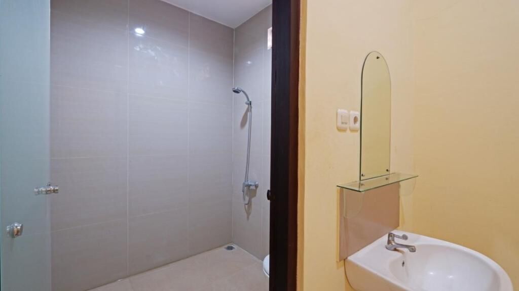 A bathroom with a shower, a sink, and a mirror.